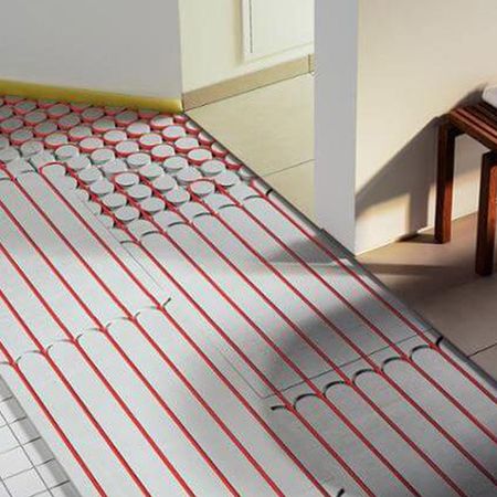 Boden mit rotem und weißen Strängen, der die Installation einer Fußbodenheizung zeigt