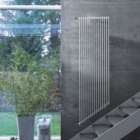 Ein Raum mit einer Treppe, der mit einem weißen, stilvollen Heizkörper ausgestattet ist