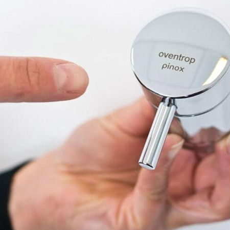 Eine Person präsentiert einen Wasserhahngriff von "oventrop pinox"