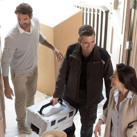 Ein Servicearbeiter wird von einer Familie begrüßt