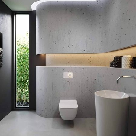 Modernes Badezimmer mit einer Betonwand und einem eleganten Waschbecken